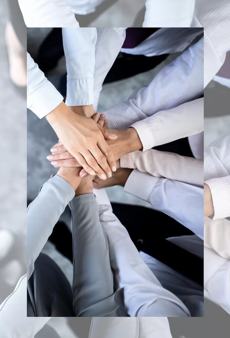 Photograph showing hands joing together in a pact, symbolizing community and support.