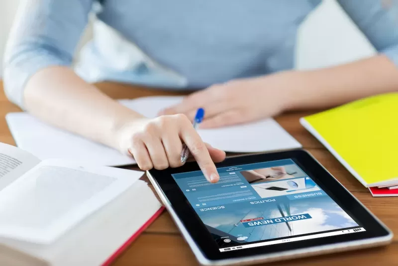 Person works from a desk on a tablet.